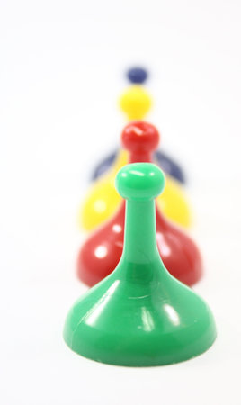 Colored game pieces all in a row on white.の写真素材
