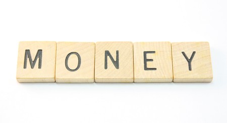 Money wooden tiles spell out the word on white.の写真素材