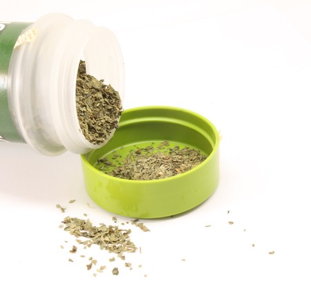 Italian Seasoning spilled out on white background.の写真素材