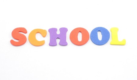 Foam letters spell out the word school on white background.の写真素材