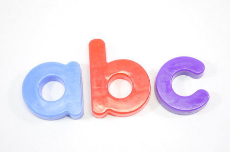Refrigerator magnets spell out ABC on a white background.