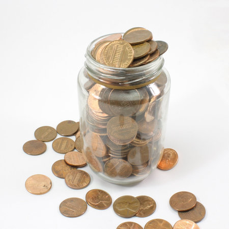 A jar full of U.S. Pennies isolated on white.