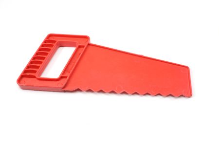 A red toy saw on a white background.の写真素材