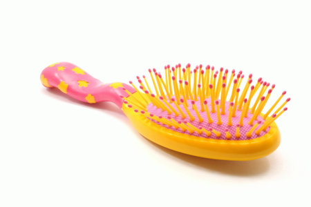 A little girl's hairbush, orange, and red on a white background.