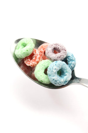 Fruit rings cereal on a spoon photographed on a white background