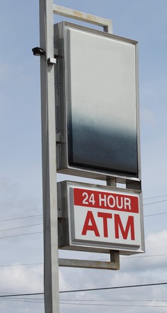 A 24 hour ATM sign with black space above for your writing or logo.の写真素材