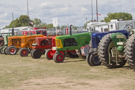 DE PERE, WI - AUGUST 18: A line of colorful vintage tractors lined up before competing at the Tractor Pull event at the Brown County Fair on August 18, 2012 in De Pere, Wisconsin.のeditorial素材