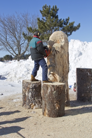 EAGLE RIVER, WI - MARCH 2:  Man Carving Huge Bear from Log with Chainsaw during competition on March 2, 2013 in Eagle River, Wisconsin.のeditorial素材