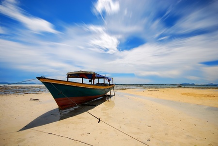 Fisherman boat on low tide shoreの写真素材