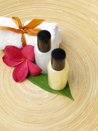 Spa Concept  bottles of lotion, towel   flower on wooden plate の写真素材