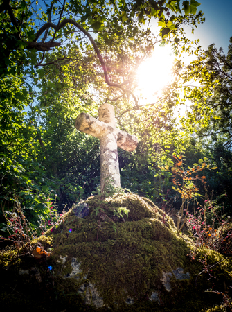 Sun illuminating a Franciscan stone crossの写真素材