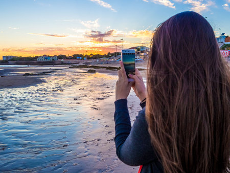 Young beautiful woman taking picture of a beach