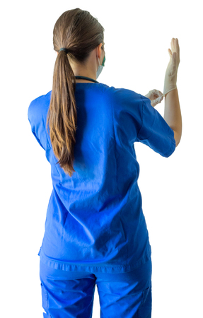 Unknown young female doctor in blue medical uniform holding a syringe ready for injection. Caucasian female model isolated over white background.の写真素材