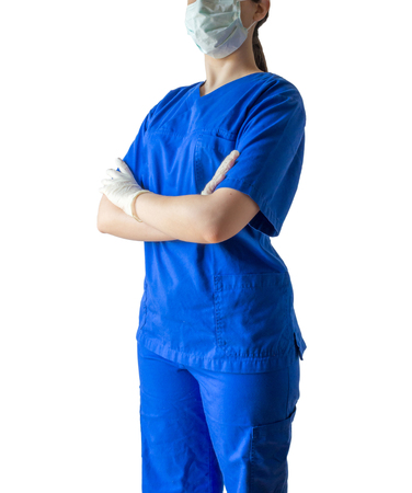 Portrait of an unknown young doctor in blue medical uniform with crossed hands. Caucasian female model isolated over white background.の写真素材