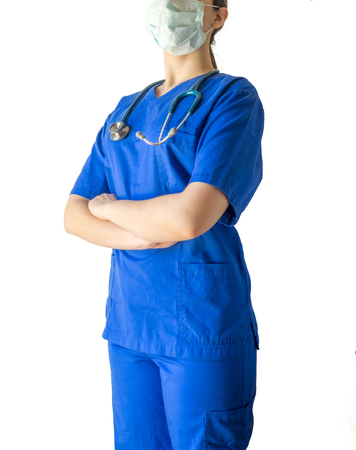 Portrait of an unknown young doctor in blue medical uniform with crossed hands. Caucasian female model isolated over white background.の写真素材