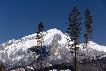 snowy hilltops of tatra mountains in poland in winter season on blue backgroundの写真素材