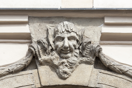 Relief on facade of old building, man's face, Prague, Czech Republic, Europe. Townhouses in  Prague are often decorated with charming decorations: bas-reliefs, statues and othersのeditorial素材
