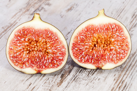 Fruits of half fresh figs on wooden plank, close upの写真素材
