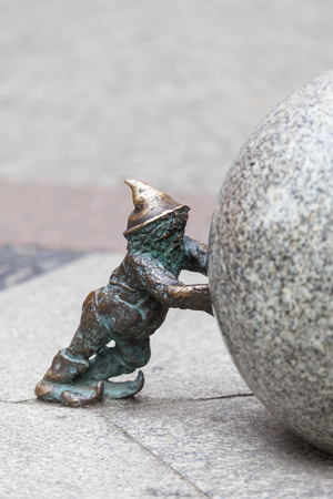 WROCLAW - POLAND, JUNE 12, 2017 : Wroclaw dwarf, small fairy-tale bronze figurine on the side walk. There are over 350 dwarfs spread all over the city, they are a big tourist attractionのeditorial素材