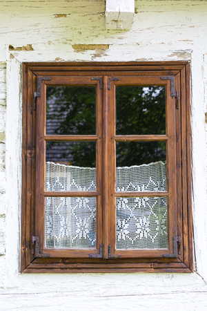 Old traditional polish wooden house in open air museum, Museum of the Kielce Village ( Muzeum Wsi Kieleckiej), window with handmade lace curtain, Tokarnia, Polandのeditorial素材