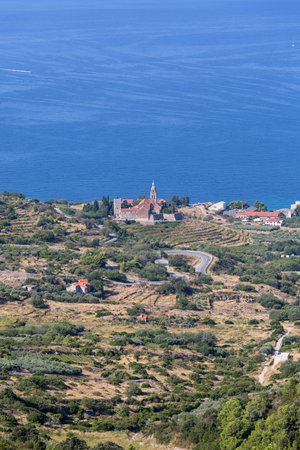 12th century coastal town lying on the island of Vis on the Adriatic Sea, view on Church of Saint Nicholas, Komiza, Croatiaの写真素材