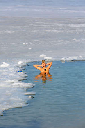 Krakow, Poland - February 20, 2021: Young women submerged in cold water while winter swimming in an ice hole of a frozen Kryspinow lakeのeditorial素材