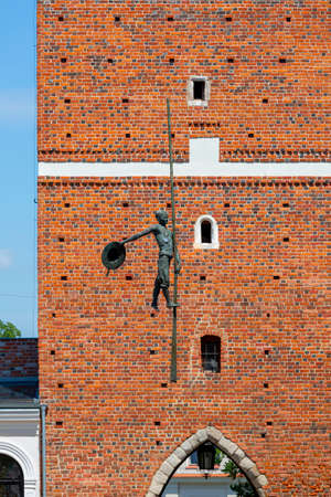 Sandomierz, Poland - July 10, 2020: 14th century gothic entrance Opatowska Gate built from the foundation of Casimir the Great. Sculpture of a bargeman going down the lineのeditorial素材