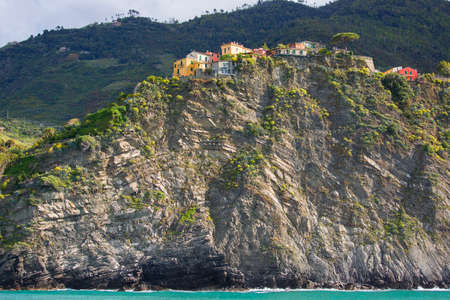 View on seaside and small village on a rocky hill, typical colorful houses, Corniglia, Cinque Terre,...