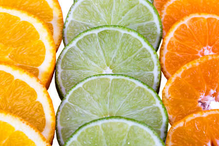 Composition of citrus fruit slices of green lime, mandarin and orange, close upの写真素材