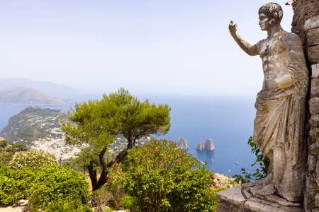 Capri Island; Italy - June 28; 2021: Aerial view from the top of the island Monte Solaro to the Tyrrhenian Sea with rocks Faraglioni; statue of Emperor Augustus in the foregroundのeditorial素材