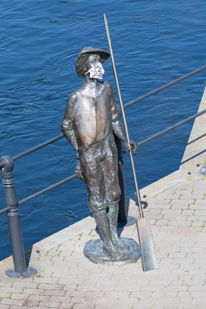 Bydgoszcz, Poland - June 26, 2020: Statue of raftsman with protective mask on the riverside boulevard on the Brda Riverのeditorial素材