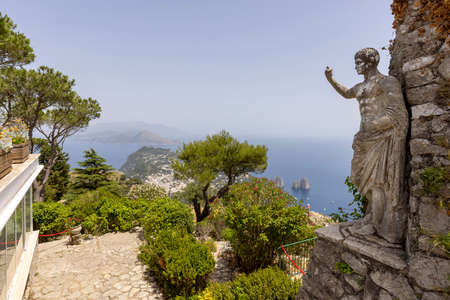 Capri Island; Italy - June 28; 2021: Aerial view from the top of the island Monte Solaro to the Tyrrhenian Sea with rocks Faraglioni; statue of Emperor Augustus in the foregroundのeditorial素材