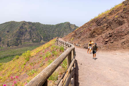 Mount Vesuvius, Italy - July 29, 2021: Tourists walking along the footpath to the top of Vesuvius volcano on a hot day. The path is made of sharp volcanic tuffのeditorial素材