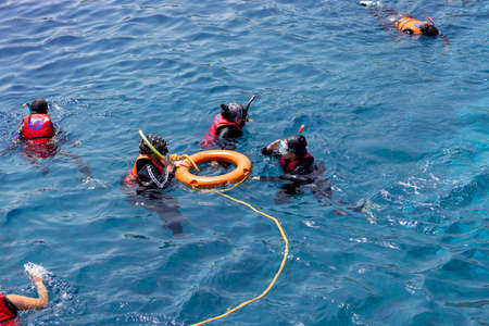 Dahab, Egypt - September 10, 2021: Group of people in life jackets snorkeling in the Red Sea over a coral reefのeditorial素材