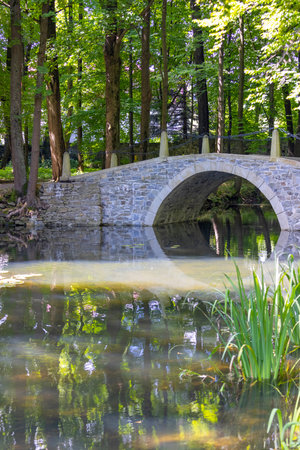 Sucha Beskidzka, Poland - August 7, 2021: Park with a bridge over the water next to the 16th century renaissance Sucha Beskidzka castle also called Little Wawelのeditorial素材