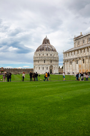 Pisa, Italy - May 13, 2019: Tourists in Piazza del Duomo before Pisa Baptistery of St. John. It is a 12th century Roman Catholic church buildingのeditorial素材
