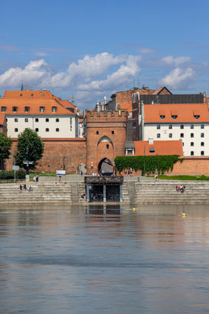 Torun, Poland - June 26, 2020: Vistula River view from viewing platform of the Old Town on the other bank of the river. Bridge gate, one of the three gates of the medieval cityのeditorial素材