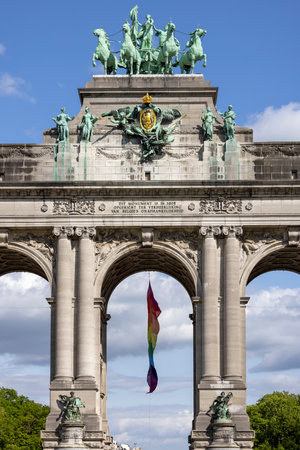 Brussels, Belgium - May 16, 2023: Statue of quadriga on the top of triumphal arch Cinquantenaire Arch in Cinquantenaire Park. Rainbow flag (LGBT) flies on the buildingのeditorial素材