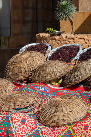 Dried hibiscus flowers in baskets on the stand on street bazaar in Egypt. Hibiscus brewed tea is very popular in Arab countriesの写真素材