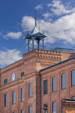 Lodz, Poland - May 4, 2023: Red brick facade of restored building in urban complex Ksiezy Mlyn...