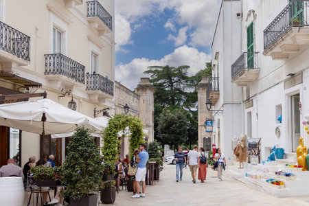 Locorotondo, Italy, Puglia - May 20, 2024: Piazza Vittorio Emanuele II with historic Porta Napoli, leading to the city. The Square is a famous tourist attraction, with outdoor restaurants and shopsのeditorial素材