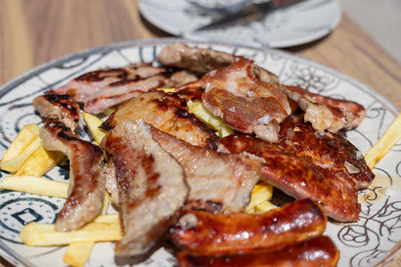 Iberian parrillada mixed grill with pork cuts, sausages, and chorizo on a hot plate, traditional Spanish barbecue dish from Andalusia, Spainの写真素材