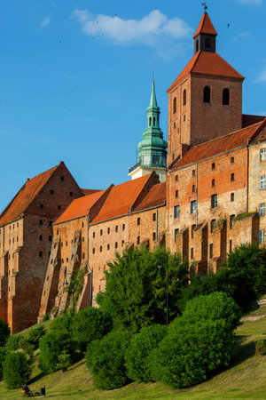 Grudziadz, Poland - June 25, 2023: 14th century Grudziadz Granaries, fortification complex of river bank on the Vistula river. Tower of Basilica of St. Santaのeditorial素材