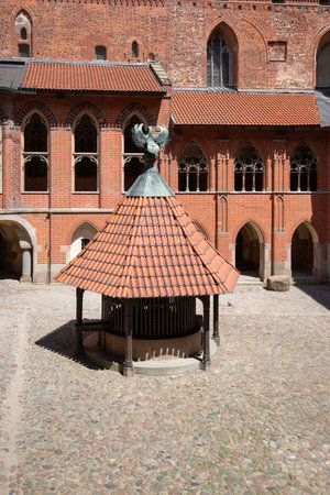 Malbork, Poland - June 25, 2020: Courtyard with well, 13th century Malbork Castle, medieval Teutonic fortress on Nogat River. It is the largest gothic castle in the world, UNESCO World Heritage Siteのeditorial素材