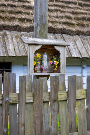 Lublin, Poland - May 23, 2022: Chapel in front of thatched cottage in Lublin Village Museum. Monuments of architecture and ethnographic collections from former Lublin Provinceのeditorial素材