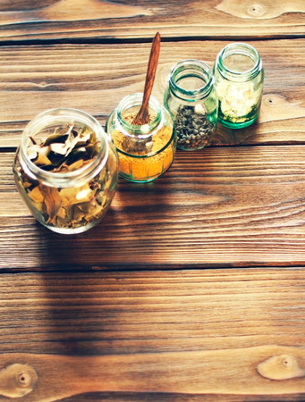 bottles of spices on a wooden tableの写真素材