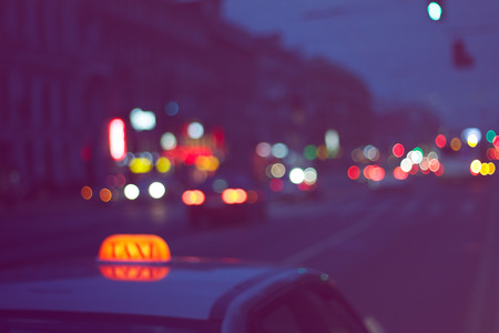 blurred background - taxi car on a city road in the eveningの写真素材