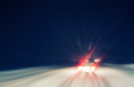 snowstorm on a country road at night, view from a car, blurred motion, dangerous situationの写真素材