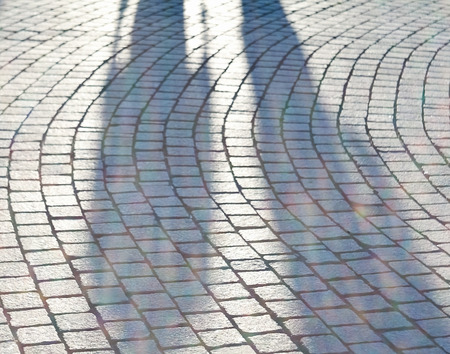 couple of lovers on the cobblestone pavement at sunsetの写真素材