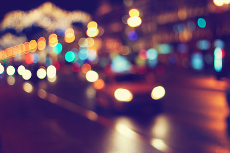 night city road background: defocused car headlights and street lamps, vintage colors